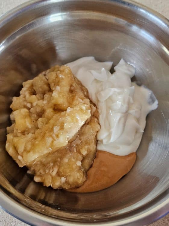 Mashed banana, Greek yogurt, and peanut butter in a mixing bowl.