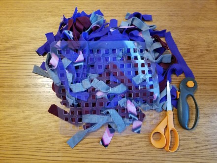 Fleece strips, dish mat, scissors, and rotary cutter.