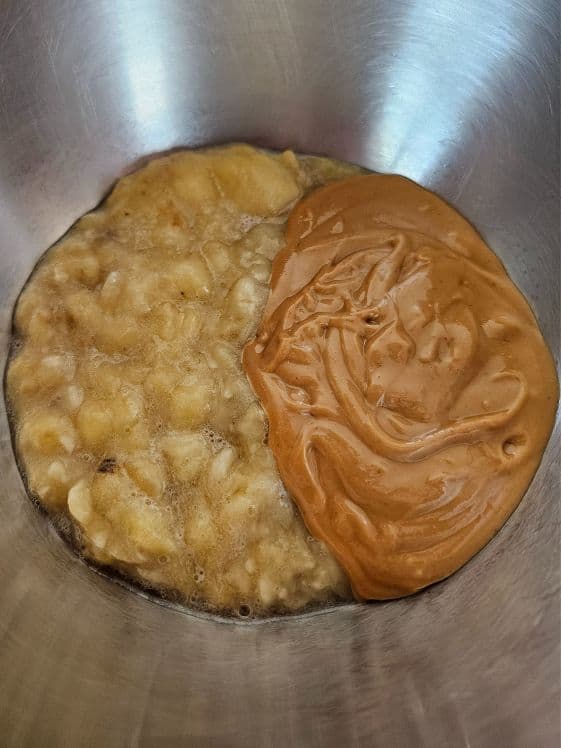 Mashed banana and peanut butter in a mixing bowl.