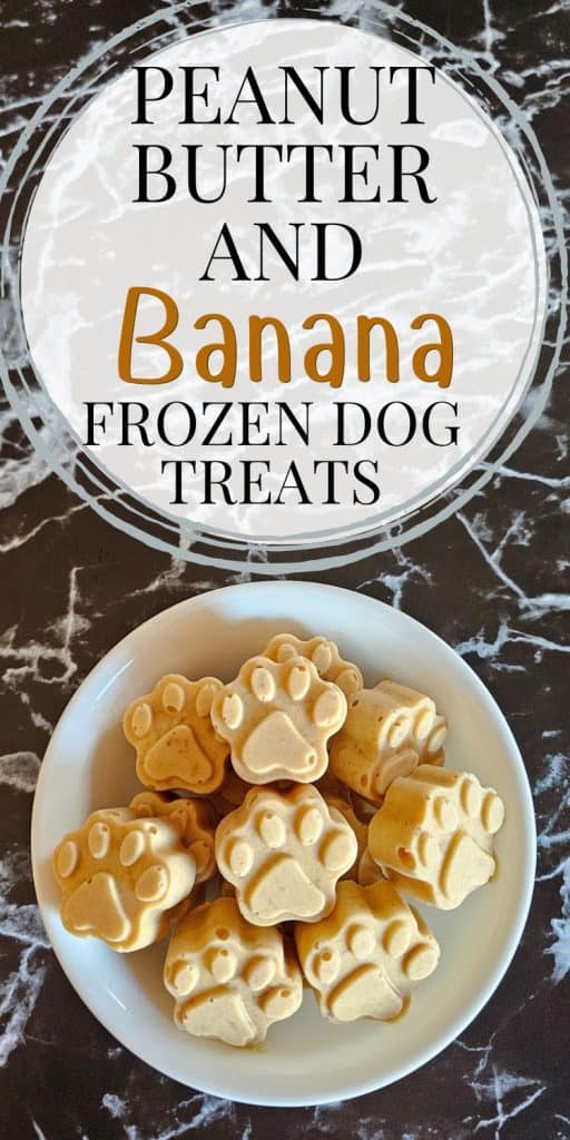 A white bowl filled with paw-shaped frozen dog treats made with peanut butter and banana sits on a marble countertop, accompanied by text that reads "peanut butter and banana frozen dog treats."