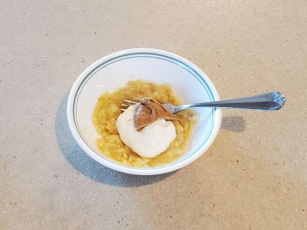 A bowl of mashed banana, Greek yogurt, and peanut butter.