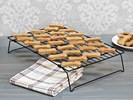 Bone shaped treats on a cooling rack.