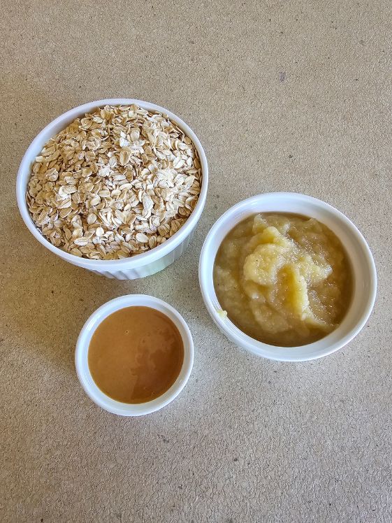 3 white bowls on the counter filled with oats, applesauce, and peanut butter.