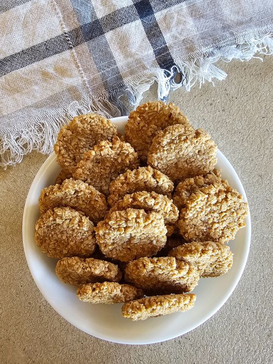 Oatmeal applesauce dog treats in a white bowl next to a linen towel.