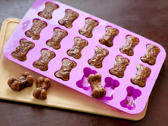 Dog treats in a pink bone shaped mold.