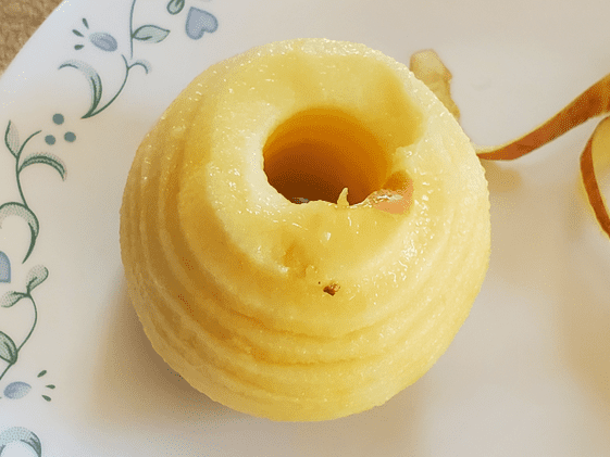 An apple after using the apple peeler, corer, slicer on it.