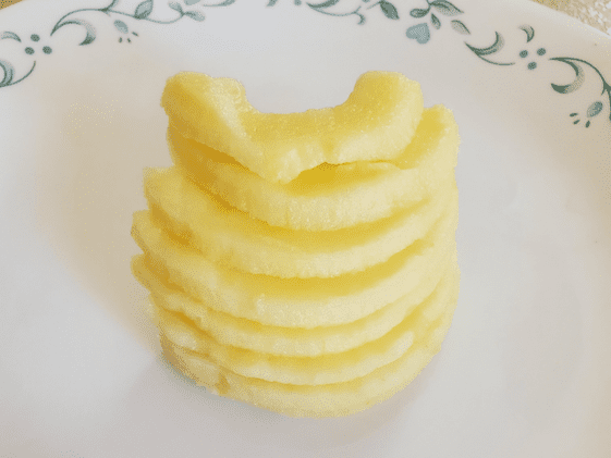Apple slices after cutting the peeled, cored, and sliced apple in half.
