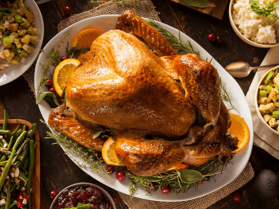 Thanksgiving turkey on a platter surrounded by side dishes.