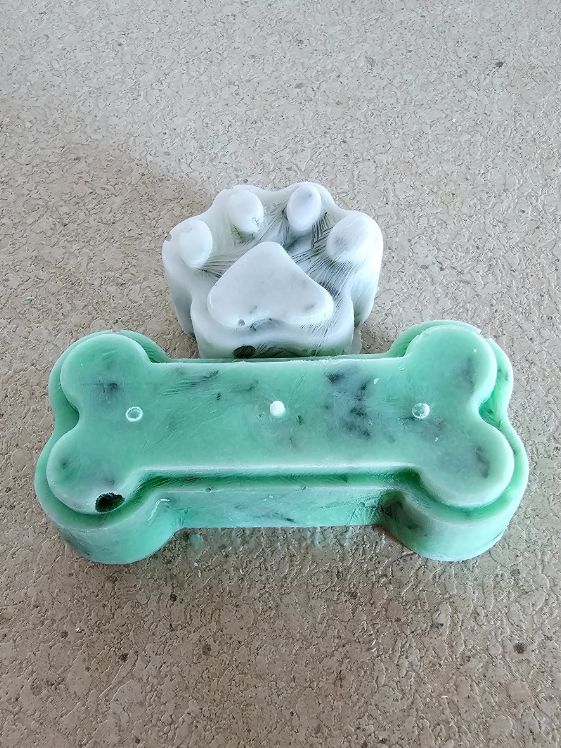 Paw shaped fresh breath treat without green food coloring and a bone shaped treat with green food coloring.