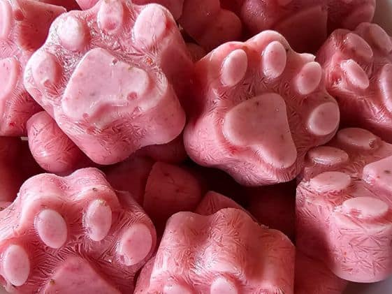 Close up of paw shaped strawberry ice cream for dogs.