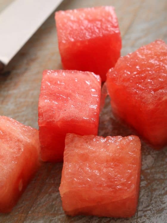 Watermelon cubes on a counter.