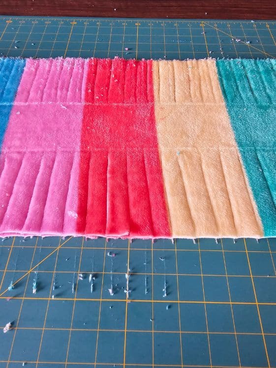 Fringe cut on both sides of a 3 inch strip in the middle of the fleece.
