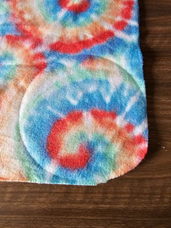 A circular indent in fleece that is laid out on a table.