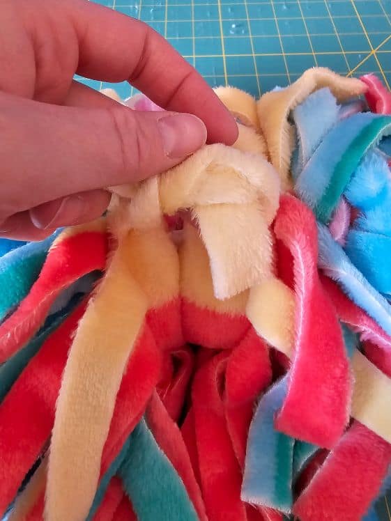 Take two pieces of fringe and tie it around where the zip tie was cut.