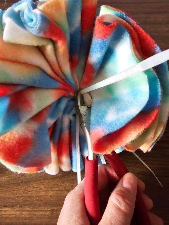 Cutting the zip ties as close to the base as possible.
