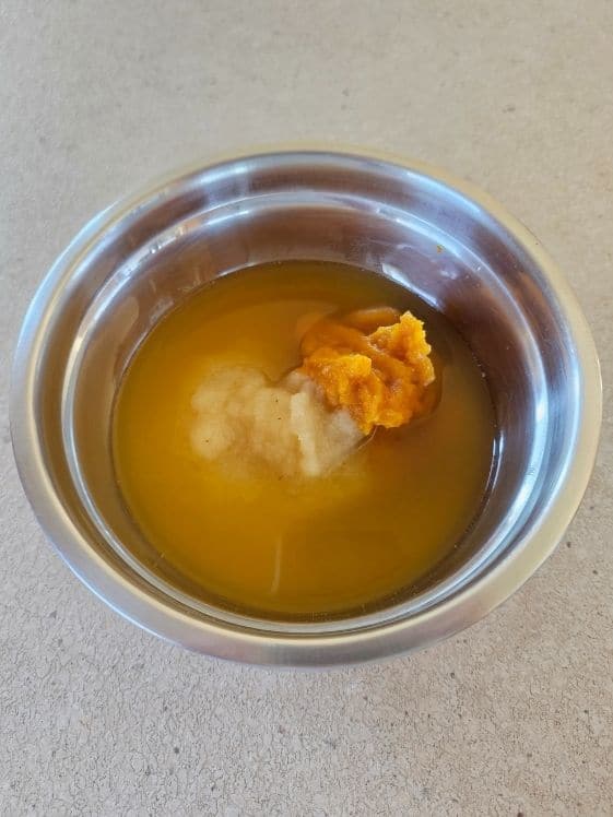 Pumpkin puree, applesauce, and water in a mixing bowl.