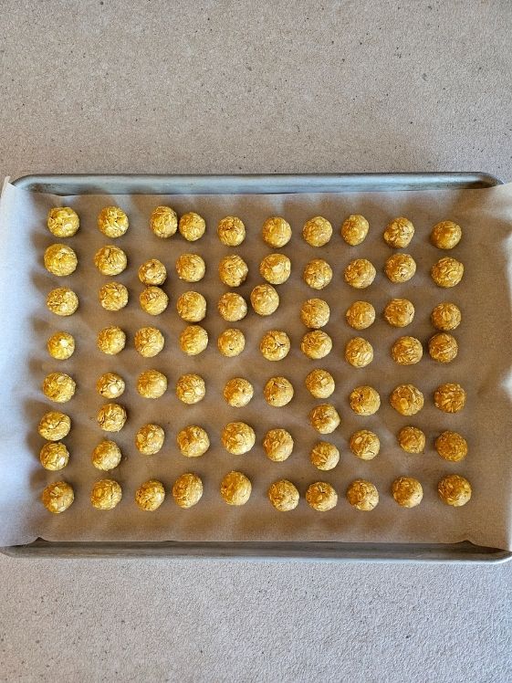 No bake peanut butter pumpkin dog treat balls on a cookie sheet.