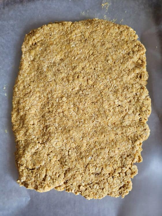 The mixture pressed flat on a parchment paper lined cookie sheet.