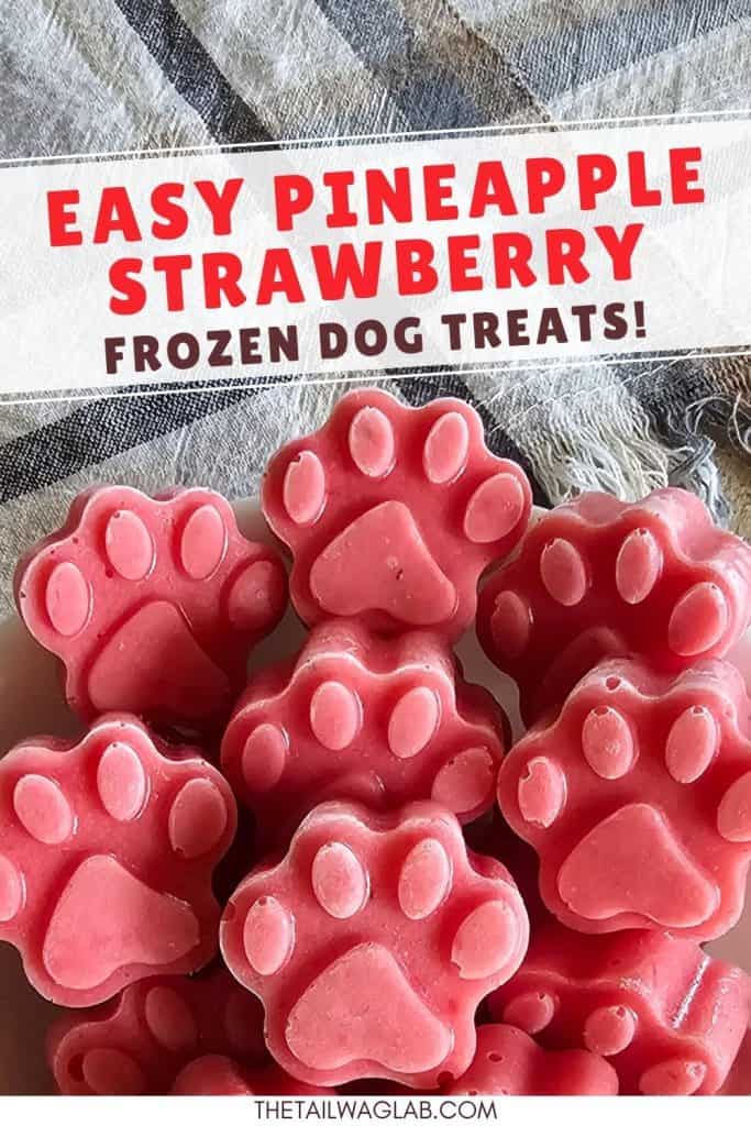 A bowl filled with pink, paw-shaped frozen dog treats made from pineapple and strawberry, suitable for summer and easy homemade dog treats.