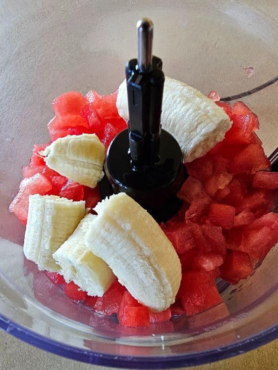 Banana, watermelon, and water in a food processor.