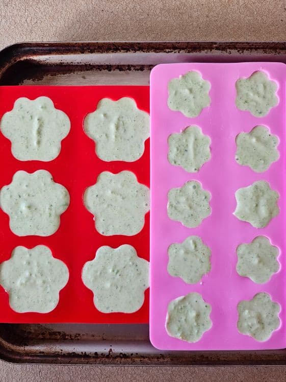 Paw shaped molds filled with cucumber yogurt mixture.