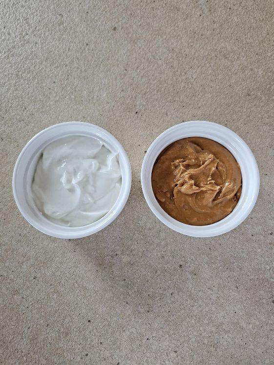 Greek yogurt and peanut butter in separate white bowls.