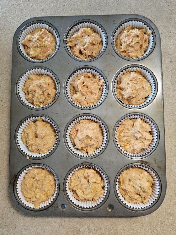 Muffin cups filled with pupcake mixture.