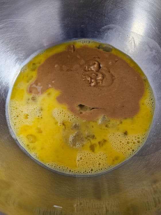 Applesauce, eggs, and peanut butter in a bowl.