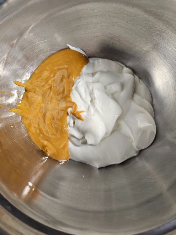 Peanut butter and Greek yogurt in a mixing bowl.