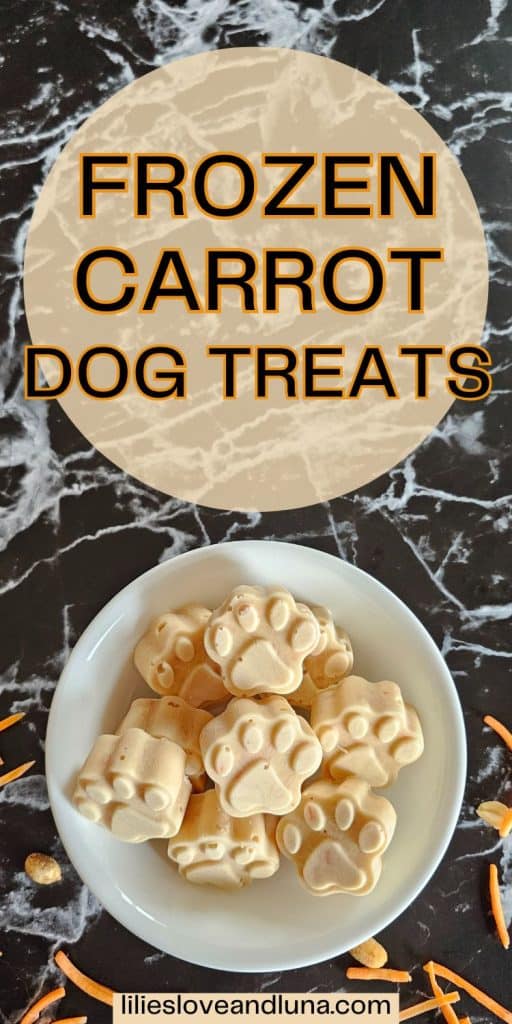A bowl filled with frozen carrot dog treats shaped like paw prints is displayed on a marble surface, surrounded by pieces of carrot and peanuts with a text overlay that reads frozen carrot dog treats.