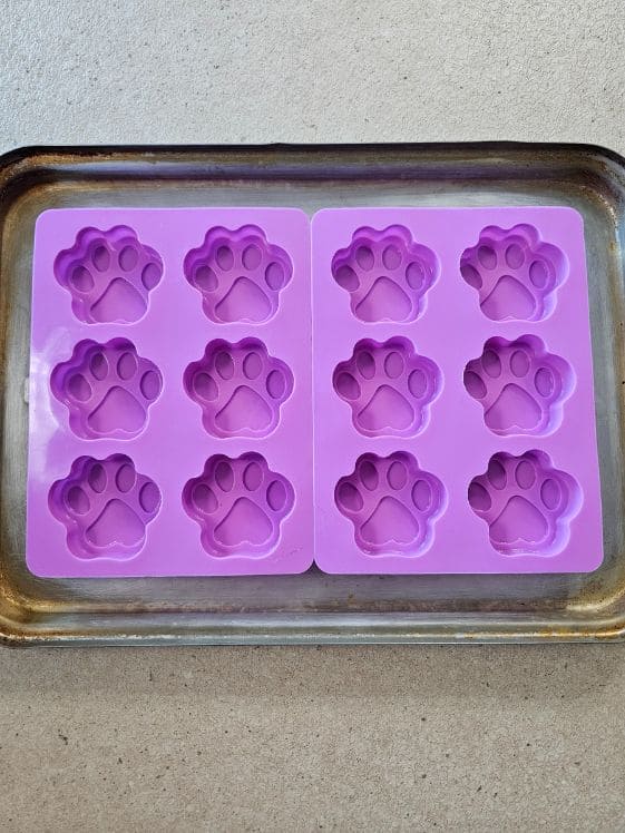 Paw shaped silicone molds on a baking sheet.