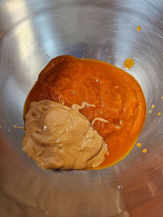 Peanut butter and carrot puree in a mixing bowl.