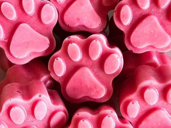 Close up of paw shaped strawberry ice cream for dogs.