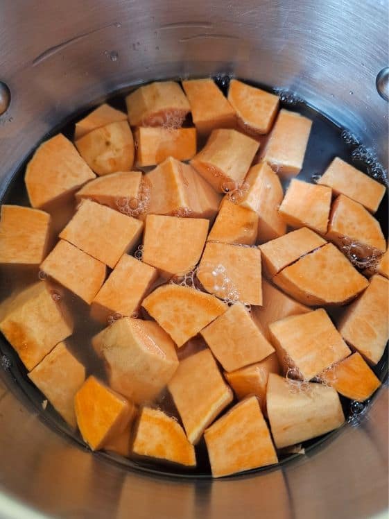 Chopped sweet potatoes in a pot of water.