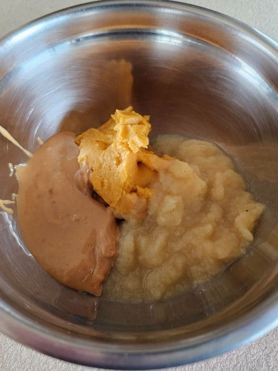 Peanut butter, sweet potato puree, and applesauce in a mixing bowl.