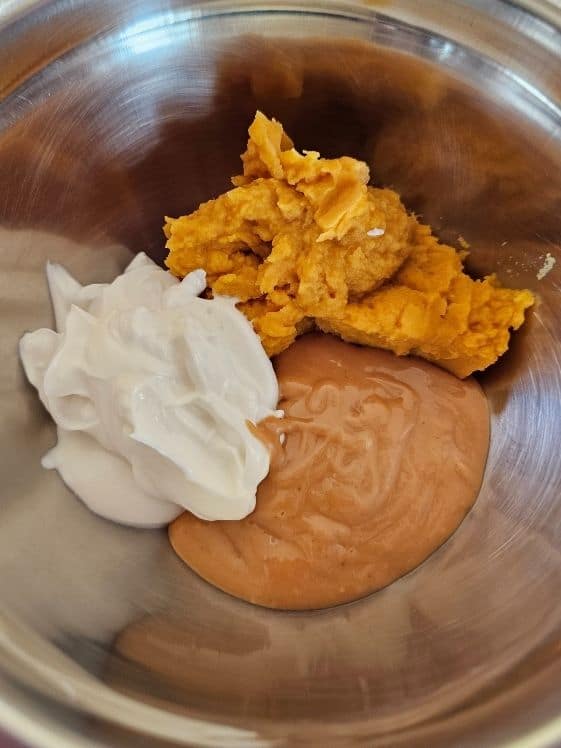 Greek yogurt, sweet potato puree, and peanut butter in a mixing bowl.