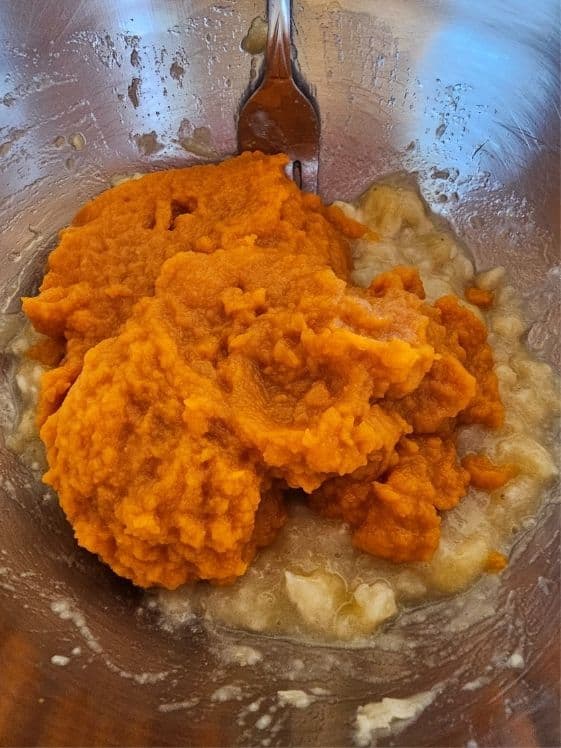 Pumpkin puree and mashed banana in a mixing bowl.