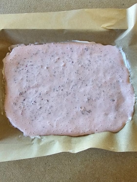 Cranberry yogurt mixture poured out onto a cookie sheet.
