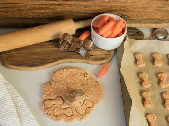 Bone-shaped cookies, baking tools, and ingredients for homemade treats.