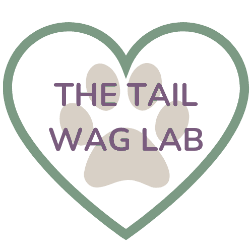 A heart around a paw print with the words "The Tail Wag Lab" on top of the paw print.