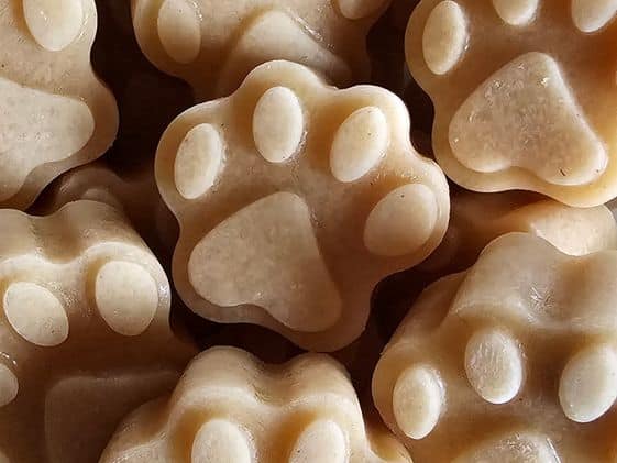 Close up of paw shaped frozen peanut butter applesauce dog treats.