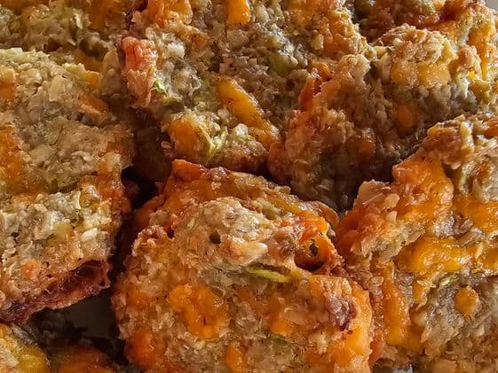 A close up of cheesy zucchini bites dog treats.