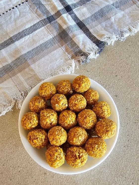 A bowl of no bake sweet potato dog treat balls next to a linen towel.